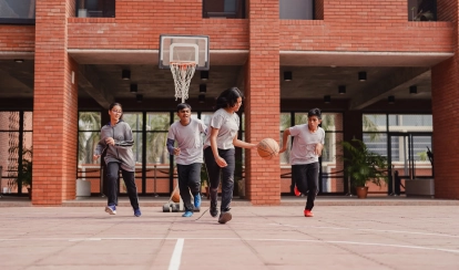 Students dribble and run during a basketball game