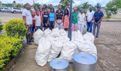 Students and staff stand in front of the non-perishable items they collected to be donated.