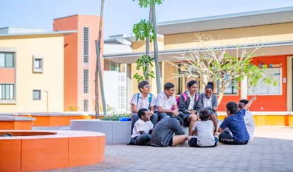 AKA Maputo students sit and talk together in a group outside of the classroom