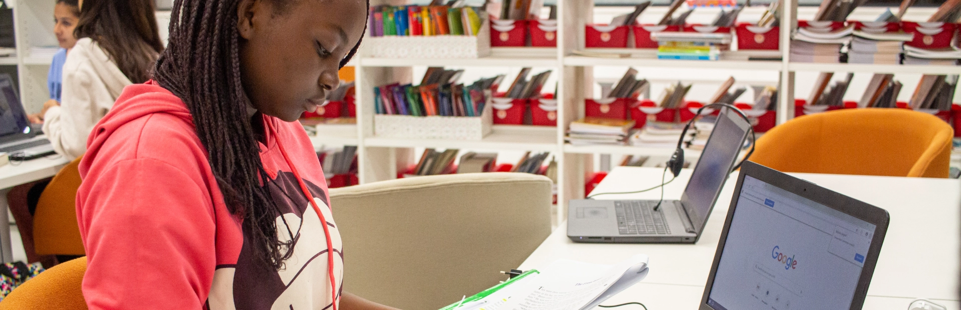 A residential student does homework in the library