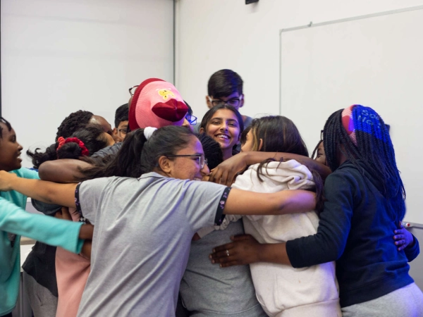 Residential students at AKA Maputo forming a group hug.  