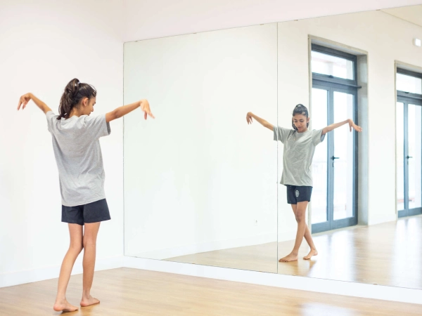 The student is practising basic dance steps at the performing arts studio.