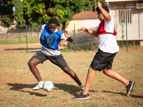 Student practising with a ball in one of the football fields
