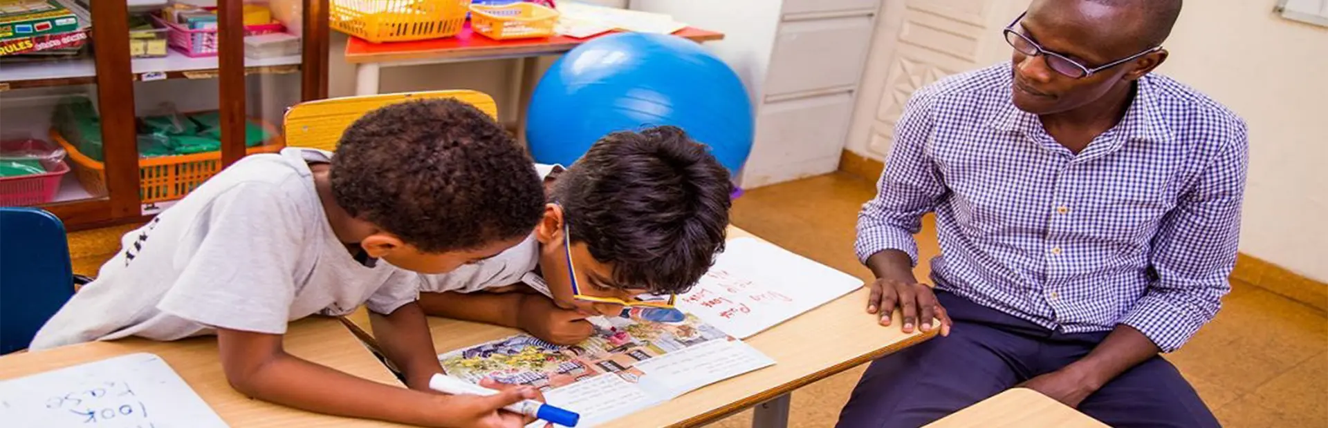 Teacher sitting with two students.