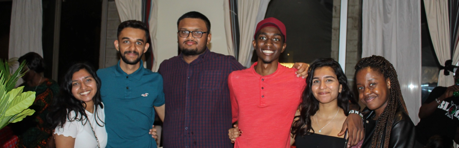 Alumni smiling at the camera for a group photo.