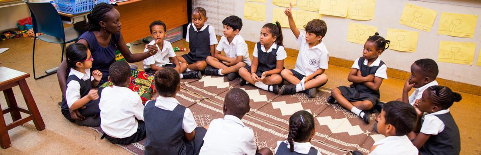 AKA Mombasa Primary Years Programme students sitting with their teacher inside a classroom.