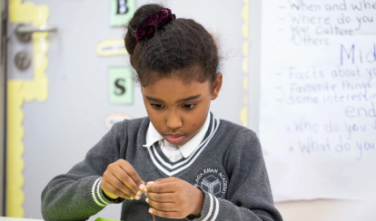 AKA Maputo student works on an art project inside a classroom.