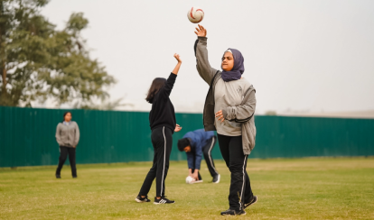 Student throws a ball during a game on the school field