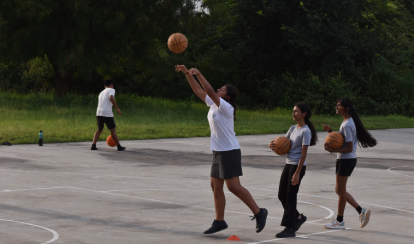 Students playing basketball on a basketball court.