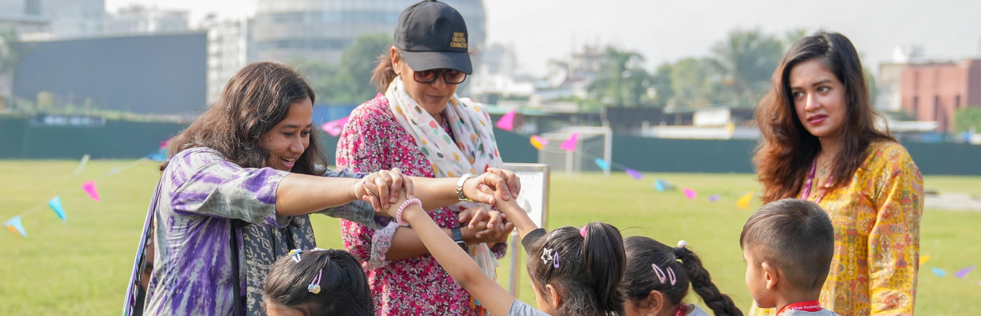 Students and teachers at the Aga Khan Academy Dhaka enjoy an outdoor activity together on the school field.