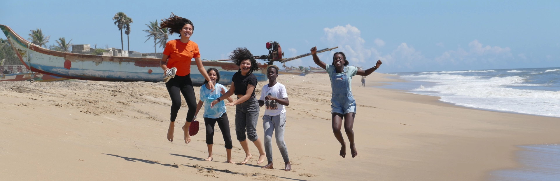 Students jumping on the beach.