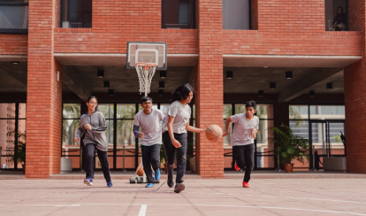 Students dribble and run during a basketball game